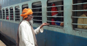 A beggar in front of local train